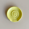 Yellow ceramic spoon rest on a neutral background