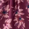 Close-up of a tea towel with a floral pattern in shades of purple and pink.