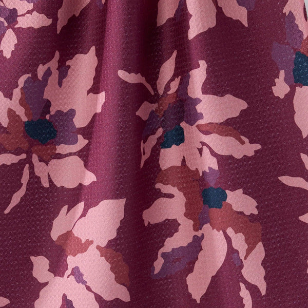 Close-up of a tea towel with a floral pattern in shades of purple and pink.