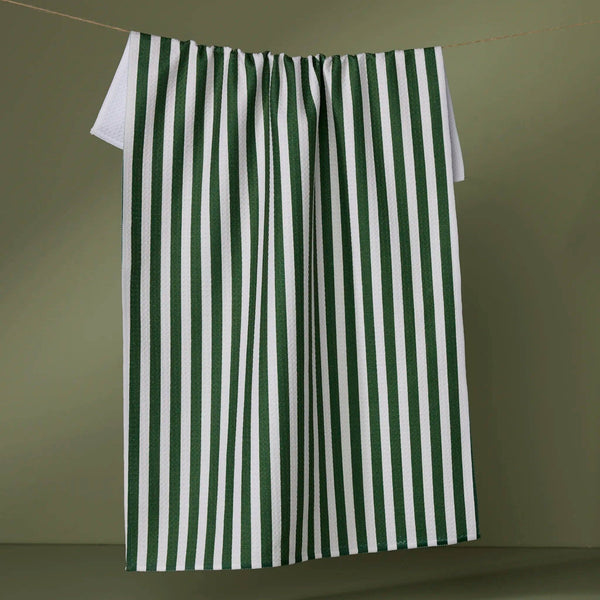 Green and white striped towel hanging on a line against a green background