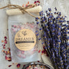 Packaged bath soak labeled 'Dreamer' with dried lavender and bath salts on a marble surface.