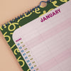 Close up view of the top of the January page of a family planner on a beige surface.
