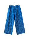 Blue tonal dot patterned pants hanging on a white background