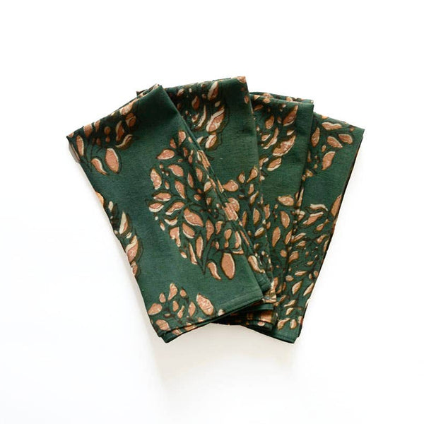 A stack of four folded cotton napkins with a dark green and earthy orange-brown print against a white backdrop.