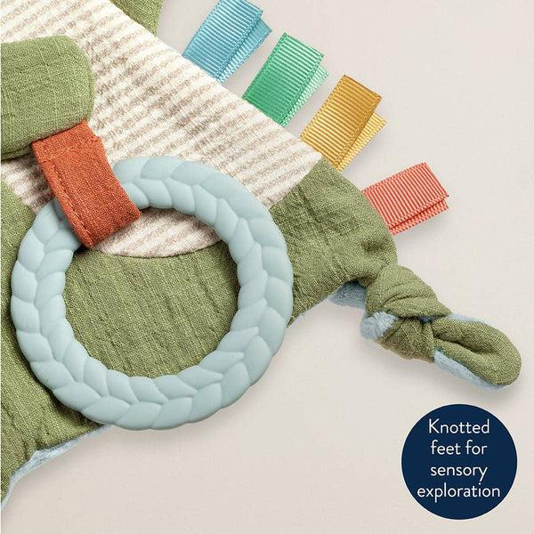 Colorful baby toy with knotted feet on a textured surface