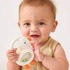 Baby holding a goose teether rattle with a plain background