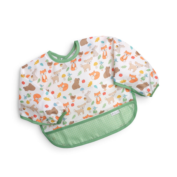 A water-resistant long sleeve baby bib in white with a colorful woodland animals print and a green crumb catching pocket hem against a white background.
