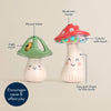 Two mushroom-shaped maraca toys with labels indicating features like jingle sound, musical shaker, and colorful rattle beads on a beige background.