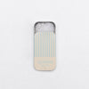 Metal slide tin of Jacobsen Salt Co pure flake sea salt with a blue and cream striped lid against a white background.