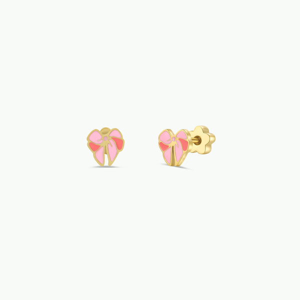 Pair of gold and pink enamel bow shaped earrings with kid-friendly flat back posts against a white background.