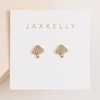 Tiny gold mushroom-shaped earrings with CZ pave studs on a Jaxkelly branded card.