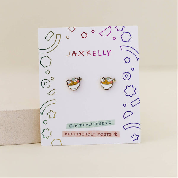 Pair of ramen enamel kid's earrings on a Jaxkelly branded card with geometric designs on a beige background