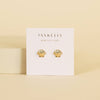 Gold shell-shaped earrings on a Jax Kelley branded card against a beige background