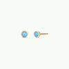 Pair of gold earrings with fire opal gemstones on a white background