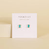 JAXKELLY turquoise and gold baguette stud earrings on a display card with a beige background