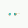 Gold earrings with turquoise stones on a white background