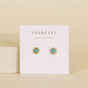 Jaxkelly gold and turquoise stud earrings on a display card with a beige background