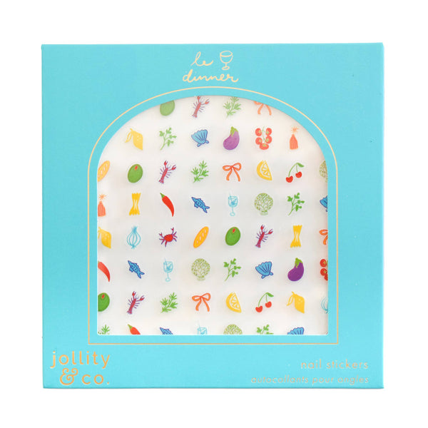 A package of 'le dinner' nail stickers by Jollity & Co. The product features a white background with a colorful, whimsical stickers of seafood, fruits, and vegetables, presented in a light blue arched window envelope with gold foil branding.