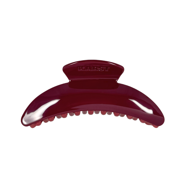 A glossy dark burgundy hair claw clip with the brand name 'KARST' embossed on the top, shown against a plain white background.