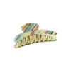 A hair claw clip with a marbled, striped pattern in pastel shades of green, yellow, orange, and blue, featuring cream-colored internal springs, shown on a plain white background.