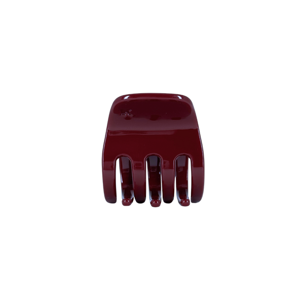 A small dark red hair claw clip against a white background.