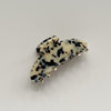 A large curved hair claw in a light tortoiseshell pattern against a neutral background.