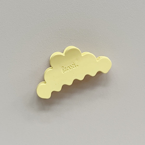 A pastel yellow cloud-shaped hair claw clip with the brand name 'kaxi' embossed on the top, shown on a neutral gray background.