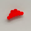 A bright red, cloud-shaped hair claw clip photographed on a neutral light gray background.
