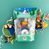 Camping-themed kiddough play kit with toys and packaging on a green background