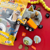 Construction-themed modeling clay play kit with toy truck, rocks, and construction-themed items on a red background