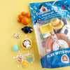 Packaged modeling clay toy set with colorful dough balls and animal figurines on a yellow background