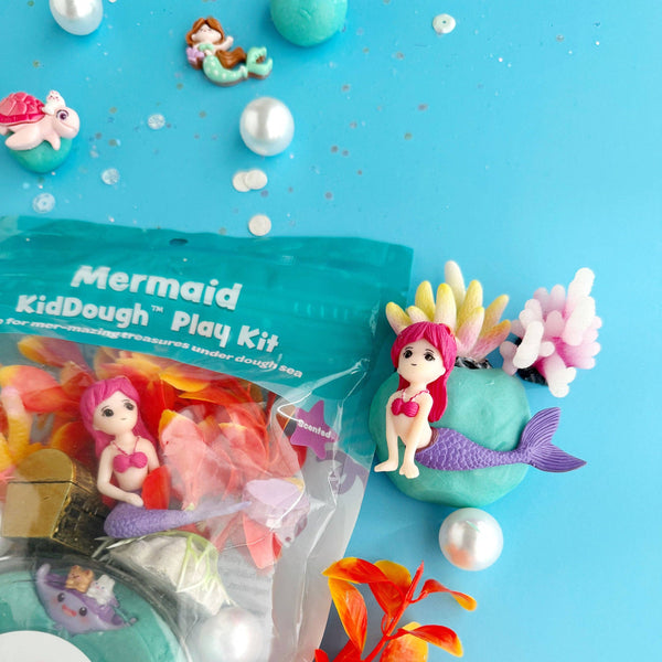 Mermaid-themed modeling clay play kit with figurines and accessories on a blue background