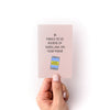 Hand holding a mini zine with text '30 Things to Do Instead of Scrolling on Your Phone' against a white background