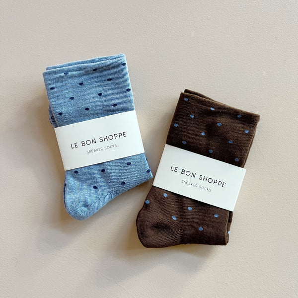 Two pairs of polka dot fine knit socks in light blue & navy, and brown & light blue, against a neutral backdrop.