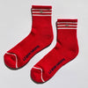 Red socks with white stripes and a silver embroidered heart with 'LE BON SHOPPE' branding on a light gray background