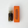 A small clear roll-on bottle of 'Green Smoke' Natural Perfume with a white cap, shown next to its bright orange rectangular packaging box on a clean white background.