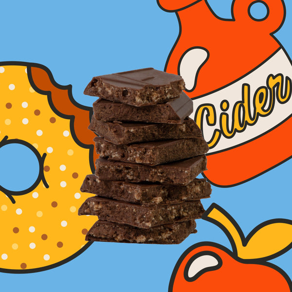 A stack of five broken chocolate bars with visible crumb texture, centered on a bright blue background with stylized illustrated donut, apple, and cider bottle graphics.