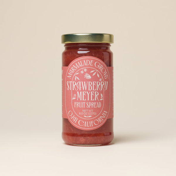 A glass jar of Strawberry Meyer Lemon fruit spread with a pink label on a neutral background.