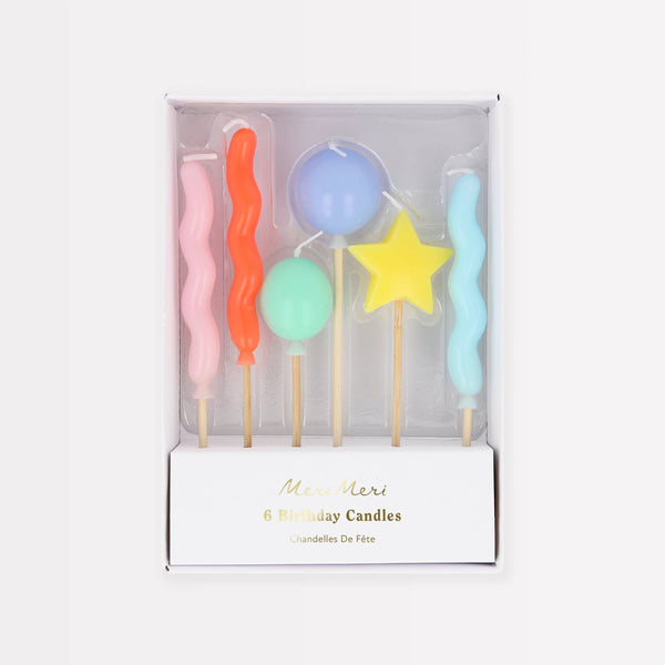 Set of colorful balloon-shaped birthday candles in a box on a white background