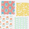 Four floral patterned wavy-edge paper napkins in different colors arranged in a grid