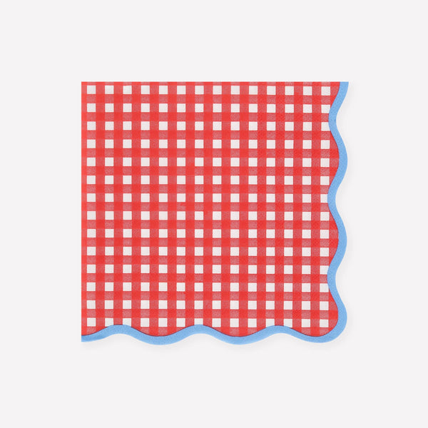 Red and white checkered napkin with blue wavy edged border on a white background