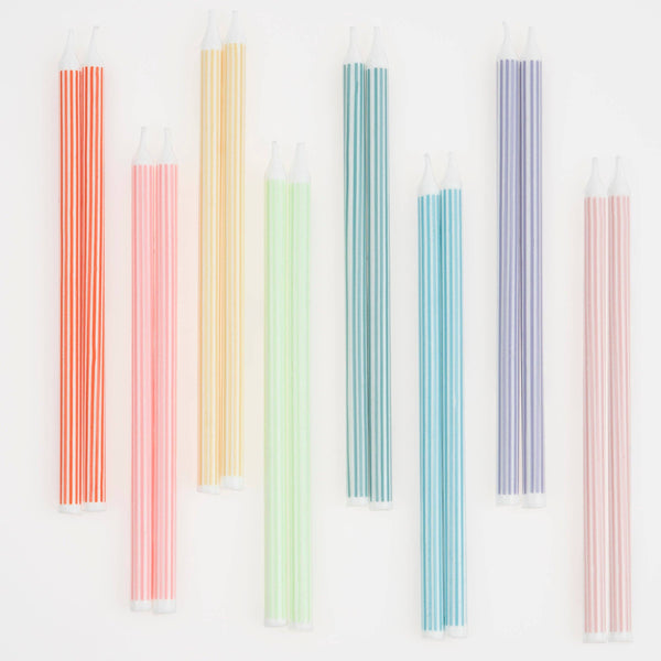 Set of long colorful striped candles on a white background