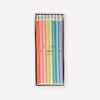 Box of long colorful striped birthday candles on a white background