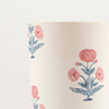 Close up detail of a melamine cup printed with a pink and blue floral design on a white background