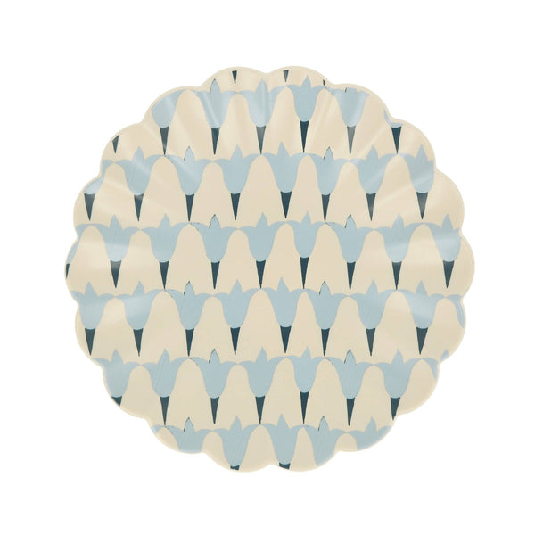 Round wavy-edged small plate with geometric blue floral pattern on a white background