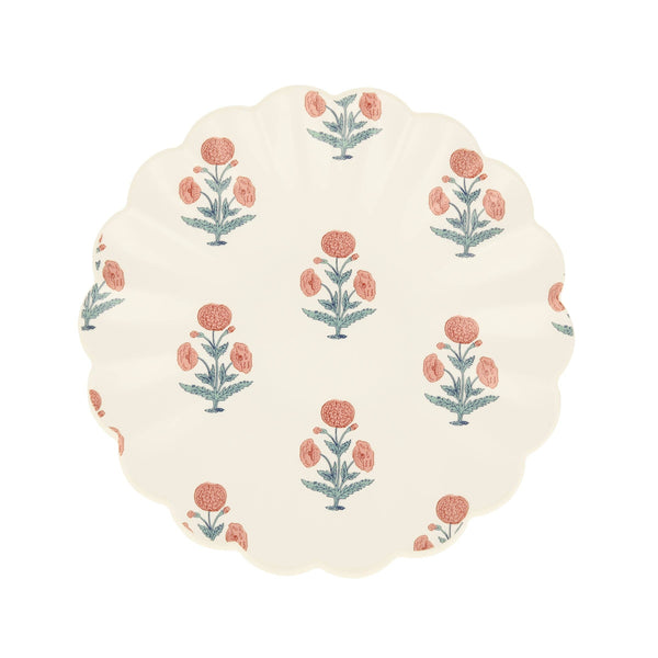 Round small plate with floral pattern and a wavy edge on a white background