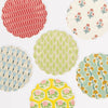 Collection of colorful patterned wavy-edge plates on a white background