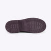 A view of the bottom tread soles of a rainboot on a white backdrop.