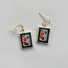 Colorful polymer clay earrings hand painted in a floral 1 cent postage stamp design with gold hooks on a neutral background.