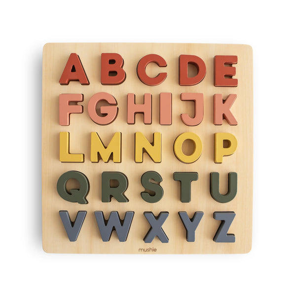 Wooden alphabet puzzle with colorful letters on a beige background